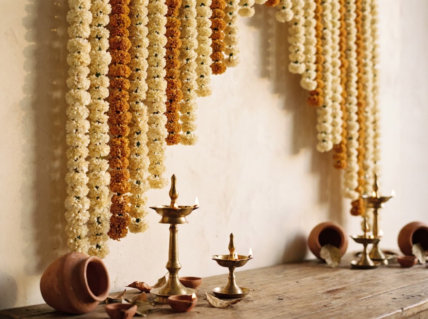 Marigold garlands and brass diyas for a wedding